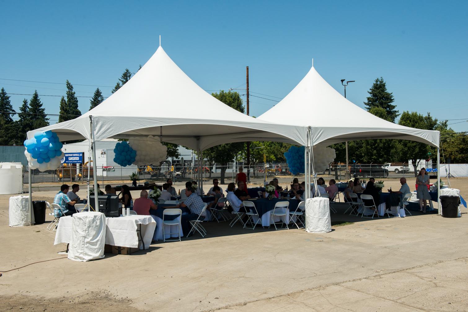 Groundbreaking attendees having lunch under a tent